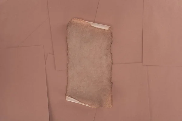 Vista superior de papel velho danificado sobre fundo de papel marrom — Fotografia de Stock