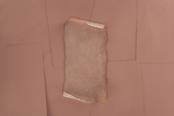 Top view of old damaged paper over brown paper background — Stock Photo