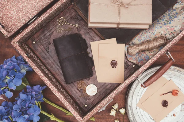 Vue du dessus de la valise vintage ouverte avec des objets sur fond en bois — Photo de stock