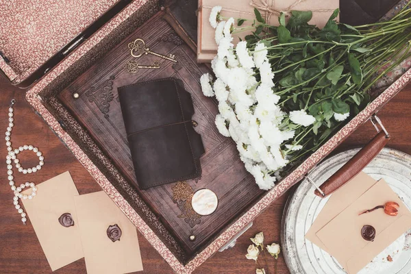 Top view of opened vintage suitcase with objects over wooden background — Stock Photo