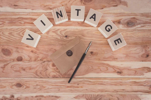 Vue de dessus des cubes avec lettres, enveloppe avec sceau et stylo plume sur fond en bois — Photo de stock