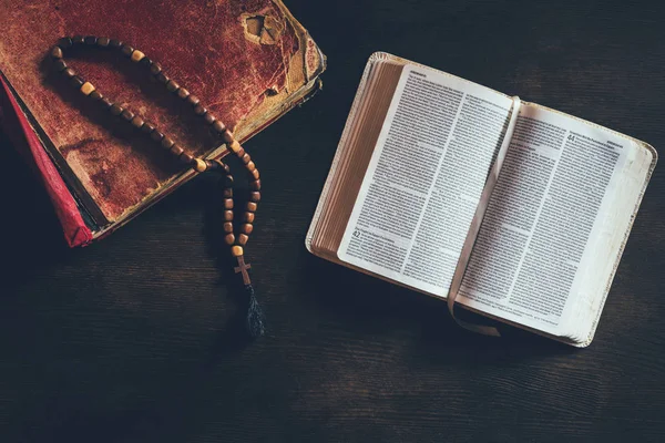 Vista dall'alto della Sacra Bibbia aperta con rosario sulla tavola — Foto stock