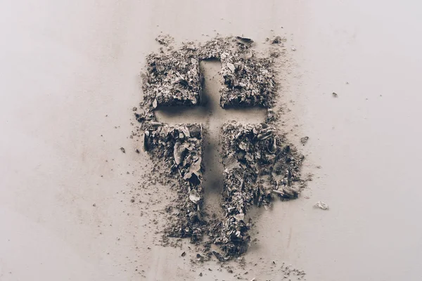 Top view of cross shape from ash on white tabletop — Stock Photo