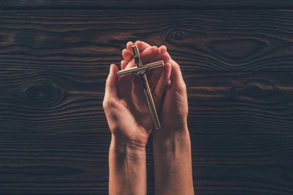 Cropped image of woman holding cross in hands — Stock Photo
