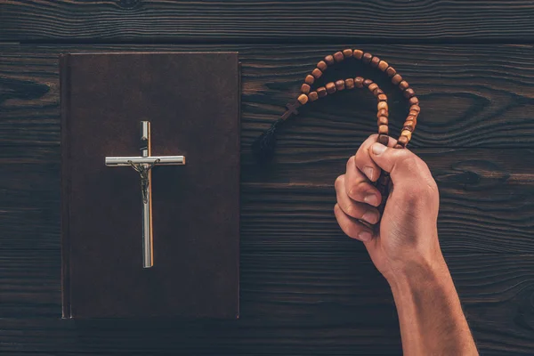 Cropped image of man holding rosary in hand — Stock Photo