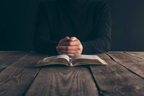 Geschnittenes Bild einer Nonne, die mit der Bibel am Tisch sitzt und betet — Stockfoto