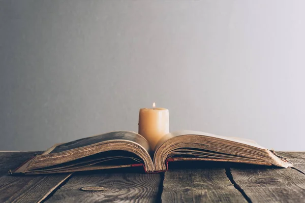 Offene Bibel mit Kerze auf Holztisch — Stockfoto