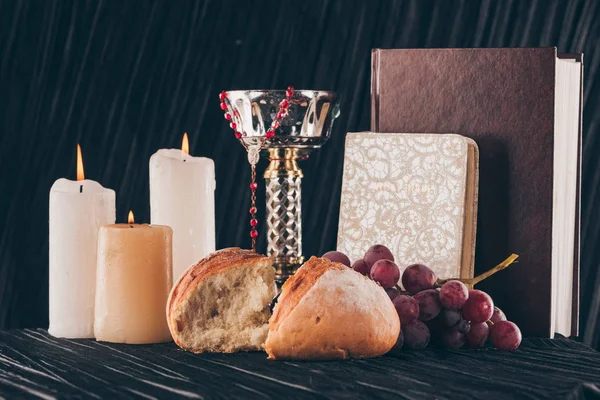 Cierges, calice, bible sainte, pain et raisins pour la sainte communion — Photo de stock
