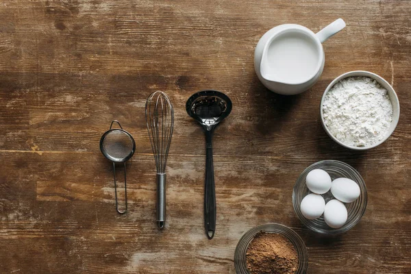 Vue de dessus des ingrédients pour la pâtisserie et les ustensiles sur table en bois — Photo de stock