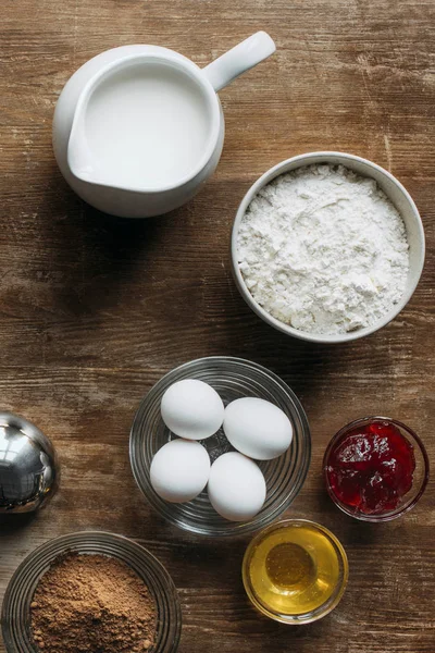 Vista superior de los ingredientes para repostería en mesa de madera - foto de stock