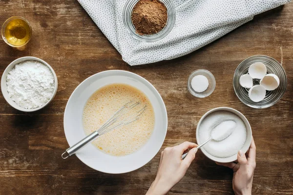 Plan recadré de femme mélangeant des ingrédients pour la pâtisserie sur une table en bois — Photo de stock