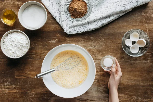 Cropped shot of woman preparing ingredients for pastry on wooden table — Stock Photo