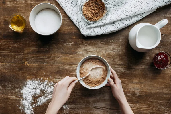 Schnappschuss einer Frau, die Flüssigkeit zum Pfannkuchenbacken auf Holztisch zubereitet — Stockfoto