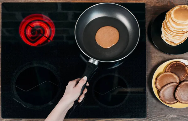 Cropped shot of woman frying delicious chocolate pancakes — Stock Photo