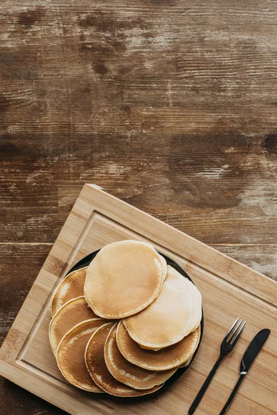Top view of plate full of pancakes on wooden table — Stock Photo