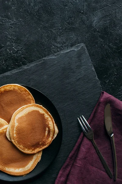 Draufsicht auf frisch gebackene Pfannkuchen auf schwarzer Oberfläche — Stockfoto