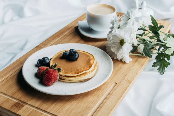 Breakfast in bed with pancakes and coffee on wooden tray — Stock Photo