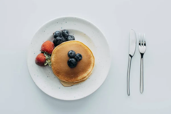 Top view of pancakes with blueberries and strawberries on white table — Stock Photo