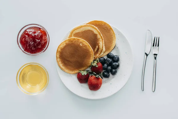 Top view of sweet pancakes with berries on white table — Stock Photo