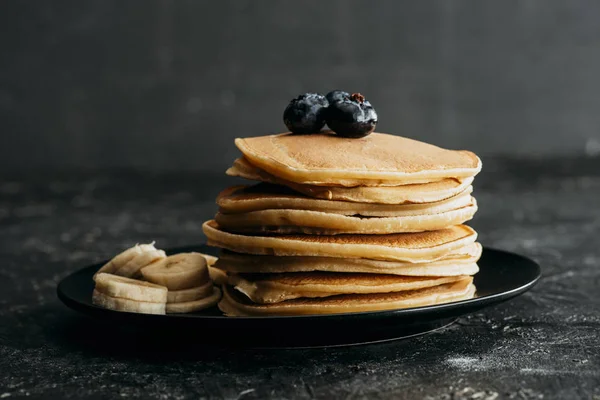 Deliziosi pancake impilati con mirtilli e banana affettata — Foto stock