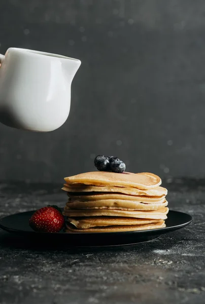 Pile de crêpes savoureuses avec pot de lait ci-dessus — Photo de stock