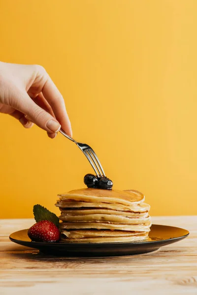 Plan recadré de la femme prenant des crêpes de la pile avec fourchette — Photo de stock