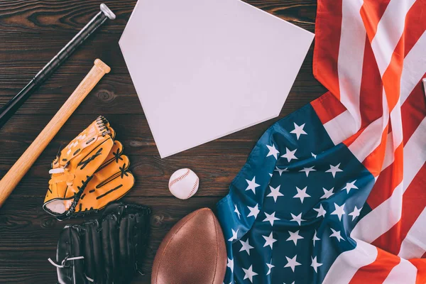 American flag and sport equipment with blank paper on wooden table — Stock Photo