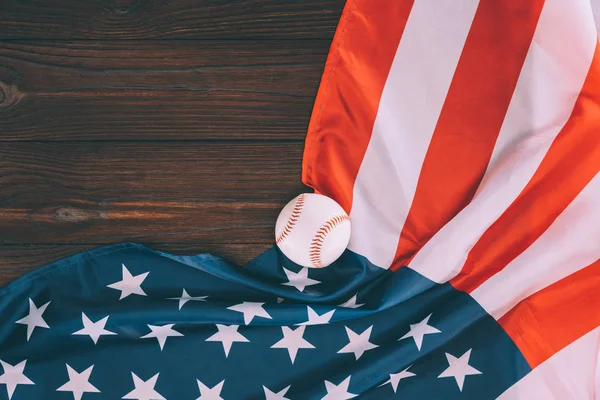 Vista dall'alto della palla da baseball e della bandiera americana sul tavolo di legno — Foto stock