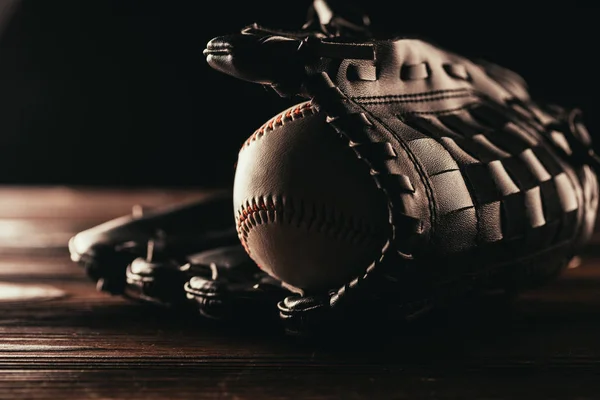 Vista close-up de bola de beisebol de couro e luva na mesa de madeira — Fotografia de Stock