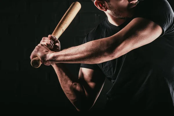 Частковий вид на молодого спортсмена, який грає в бейсбол з кажаном ізольовано на чорному — стокове фото
