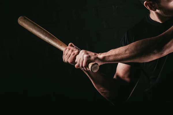 Cropped shot of young man playing baseball with bat isolated on black — Stock Photo