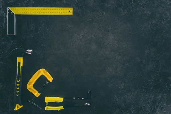 Vue de dessus de divers outils mécaniques pour le travail sur table sombre — Photo de stock