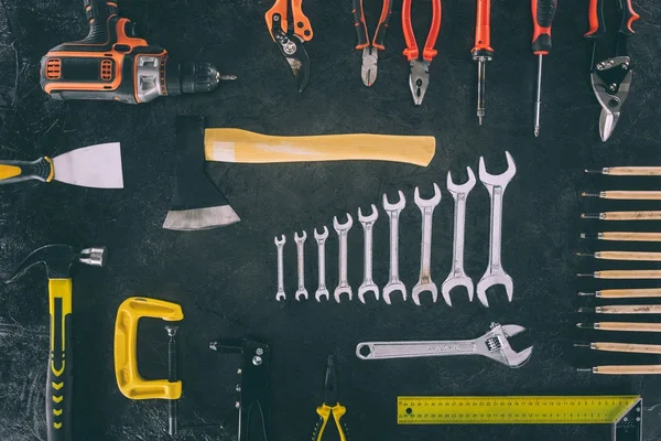 Flat lay with axe and various arranged carpentry equipment on dark surface — Stock Photo