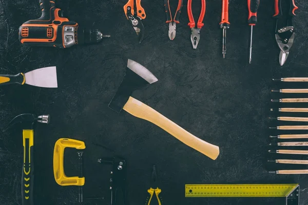 Flat lay with axe and various arranged carpentry equipment on dark surface — Stock Photo