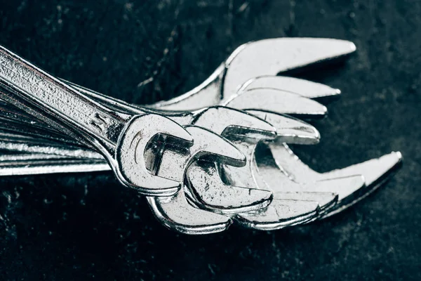 Close up view of arranged metal wrenches on dark surface — Stock Photo