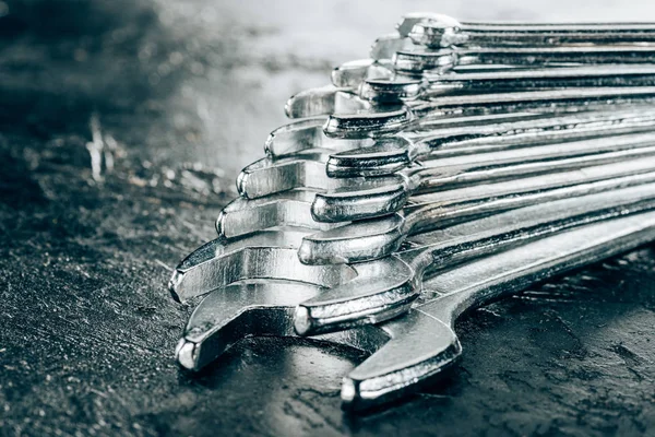 Close up view of arranged metal wrenches on dark surface — Stock Photo