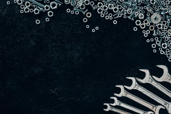 Flache Verlegung mit Metallschlüsseln, Schrauben und Drahtschrauben auf dunkler Oberfläche — Stockfoto