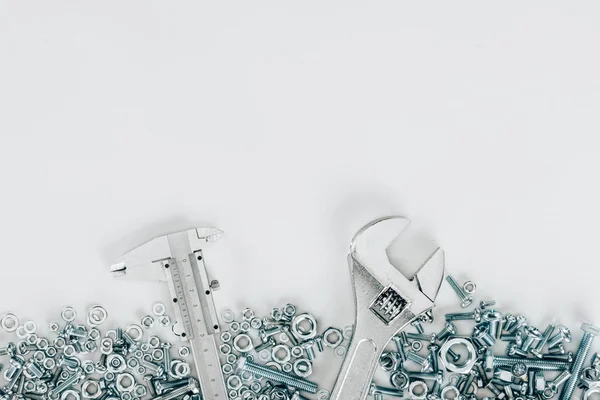 Вид зверху на різні болти і обрамлення цвяхів, гайковий ключ і набір ножів ізольовані на білому — стокове фото