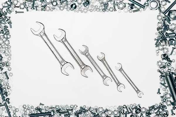 Top view of metal wrenches, various bolts and framing nails isolated on white — Stock Photo