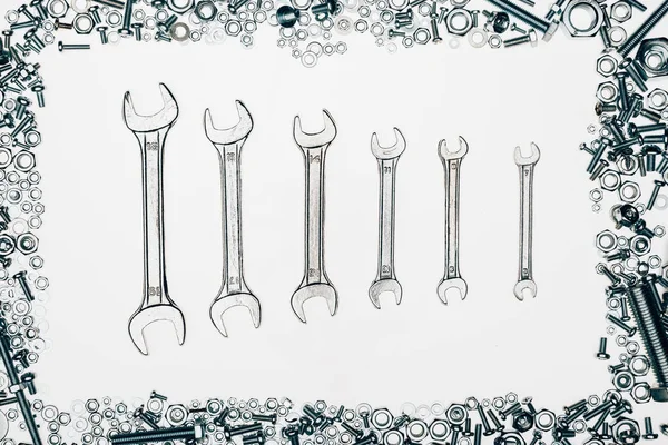 Top view of metal wrenches, various bolts and framing nails isolated on white — Stock Photo