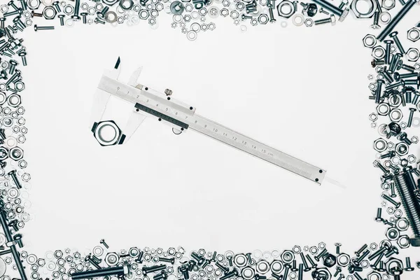 Top view of arranged various metal engineering details with vernier caliper in middle isolated on white — Stock Photo