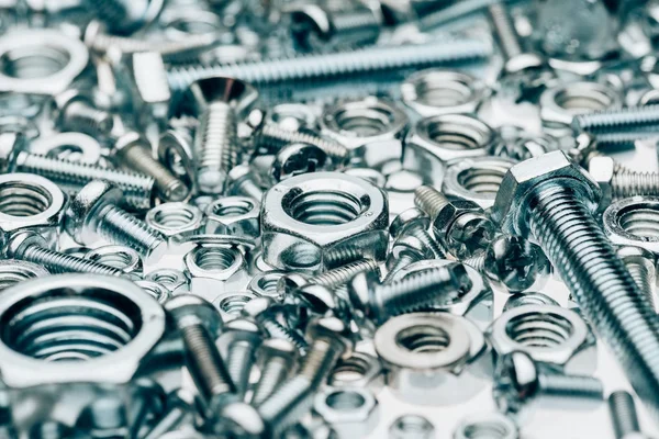 Vista de perto de metal emoldurando pregos e tampões isolados em branco — Fotografia de Stock