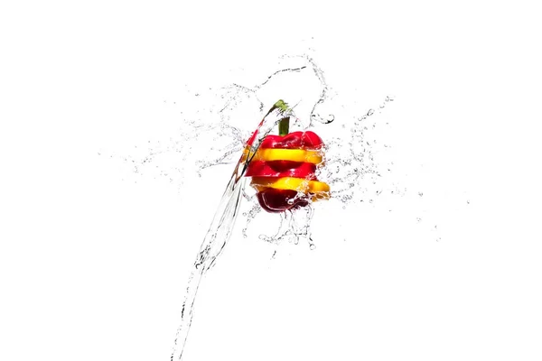 Fette di peperone rosso e giallo in spruzzi d'acqua isolati su bianco — Foto stock