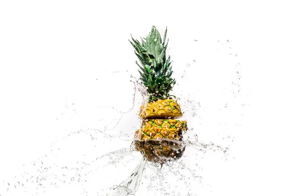 Ananas frais en tranches dans des éclaboussures d'eau isolées sur blanc — Photo de stock