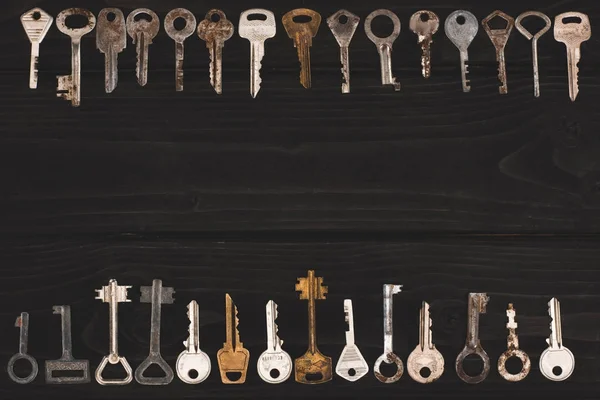 Vista superior do quadro de chaves vintage na mesa preta — Fotografia de Stock