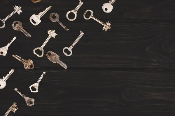 Top view of different vintage keys on black table — Stock Photo