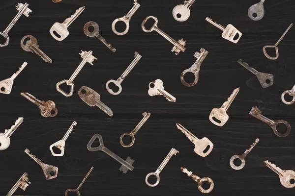 Top view of different metal keys on black table — Stock Photo