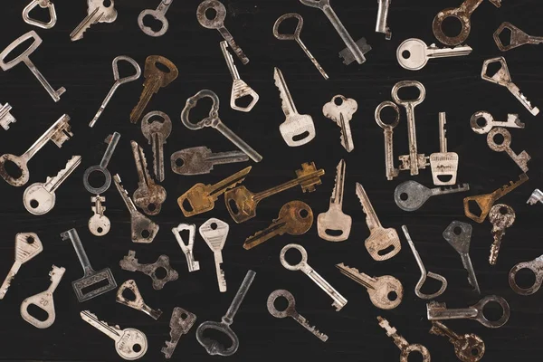 Top view of different metal keys on black table — Stock Photo
