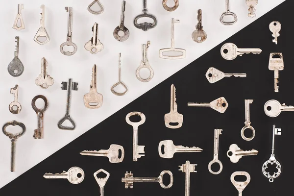 Top view of different vintage keys over black and white background — Stock Photo