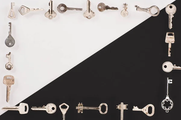 Top view of different vintage keys frame over black and white background — Stock Photo